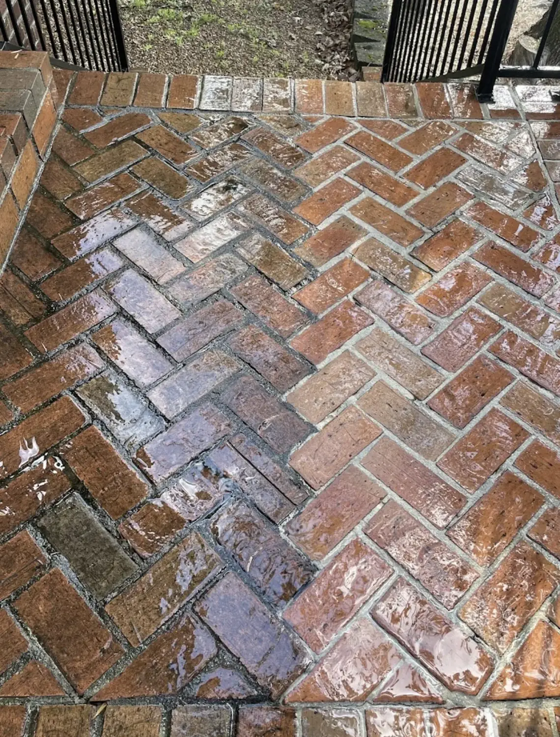Brick patio pressure washing with cleaned and stained sections