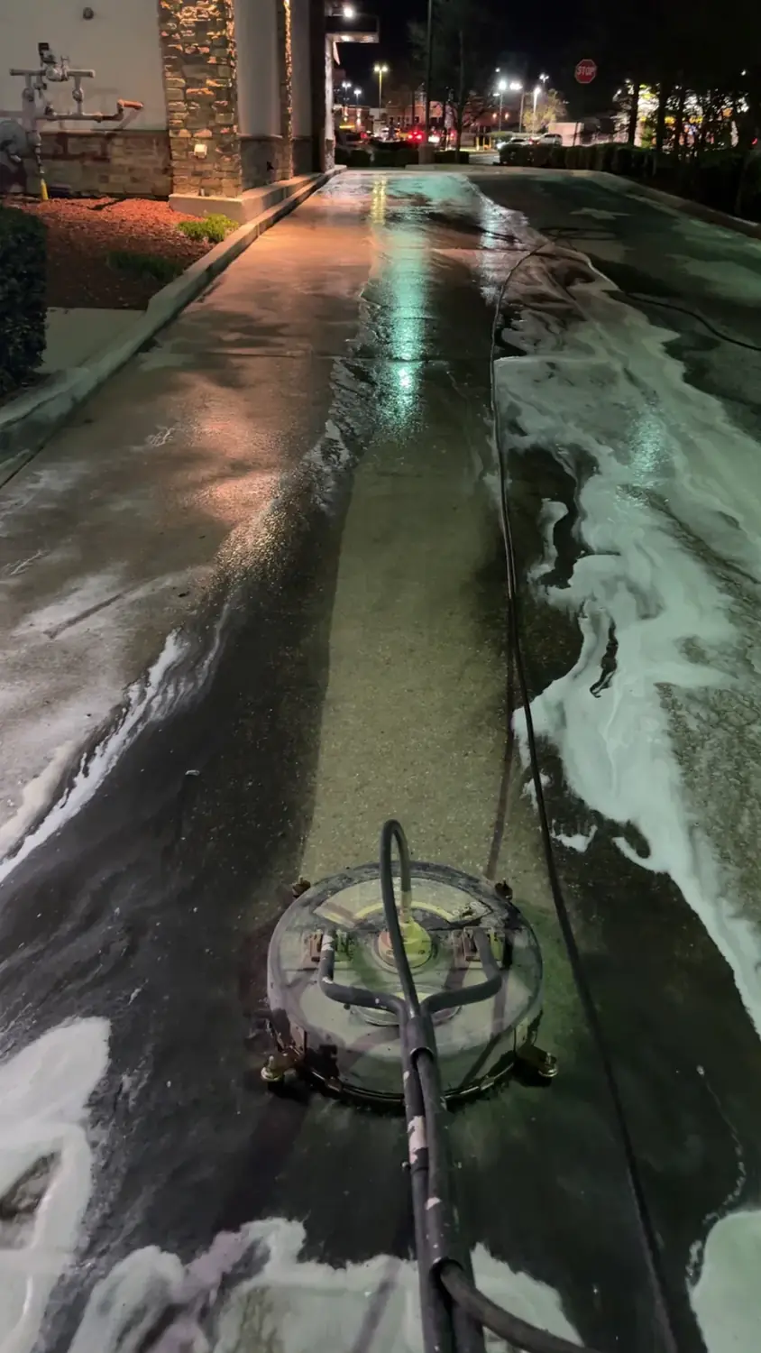 Professional surface cleaner washing a restaurant drive-thru in Huntsville AL